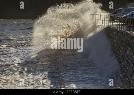 Wellen brechen gegen die Meeresmauer, während die Flut entlang der Küste des Ärmelkanals bei Teignmouth in Devon steigt Stockfoto