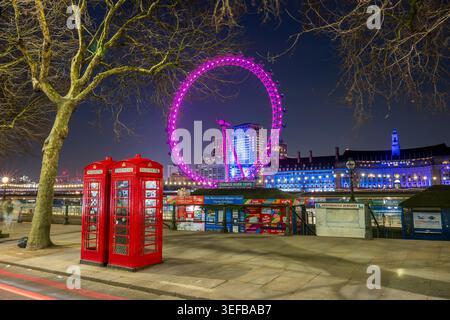 London Eye und rote Telefonzellen an der Themse in der Abenddämmerung in London, England Stockfoto