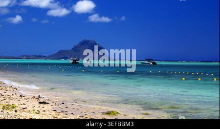 Blick auf Le Morne vom Strand Flic en FLAC auf Mauritius mit Booten und klarem Wasser an einem sonnigen Tag Stockfoto