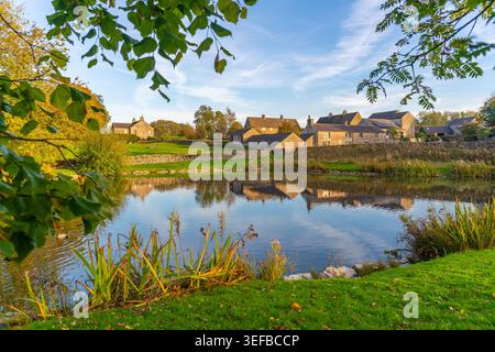 Reflexionen des Dorfes Monyash in einem Teich im Herbst in Bakewell Stockfoto
