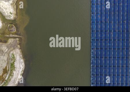 Luftaufnahme von schwimmenden Solarpaneelen auf einem ruhigen See neben einer Sandküste Beilen, Drenthe, Niederlande. Stockfoto