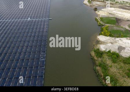 Luftaufnahme eines großen schwimmenden Solarparks auf einem ruhigen See neben einer Sandküste mit grüner Vegetation Beilen, Drenthe, Niederlande. Stockfoto
