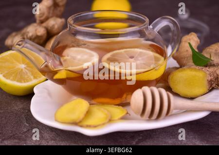 Ingwertee mit Zitrone und Honig in einer Teekanne aus Glas. Nahaufnahme. Stockfoto