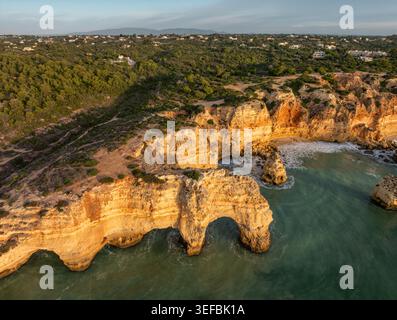 Blick auf den Strand Praia da Marinha in der Algarve, Portugal, mit goldenen Klippen, Meeresbögen, türkisfarbenem Atlantikwasser, und Küstengesteinsformationen. Stockfoto