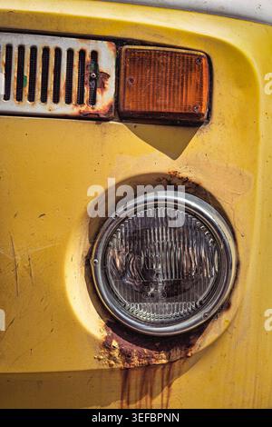 Nahaufnahme eines klassischen gelben VW-Campervan-Scheinwerfers mit sichtbarem Rost um den Chromrahmen Brighton Stockfoto