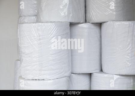 Große Rollen weißes Papier sind einzeln in durchsichtigen Kunststoff verpackt. Diese Rollen sind dicht gestapelt Stockfoto