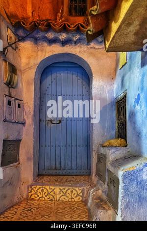 Eine lebendige blaue Tür und eine mit Kunsthandwerk dekorierte Gasse und die ikonischen Indigo-Wände der „Blauen Stadt“ – Chefchaouen, Marokko. August 2025 Stockfoto