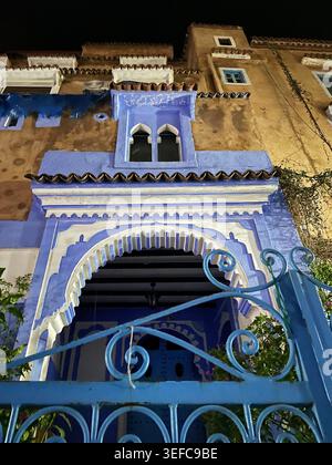 Eine lebendige blaue Tür und eine mit Kunsthandwerk dekorierte Gasse und die ikonischen Indigo-Wände der „Blauen Stadt“ – Chefchaouen, Marokko. August 2025 Stockfoto
