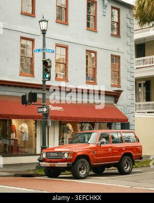 Ein roter Toyota SUV steht neben einem Bekleidungsgeschäft an der Ecke King St und Broad Streets in Charleston, South Carolina. Stockfoto