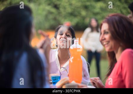 Moderne Familie aus dem Nahen Osten, die Eid und Ramadan iftar zusammen in einem Garten im Hinterhof genießen Stockfoto