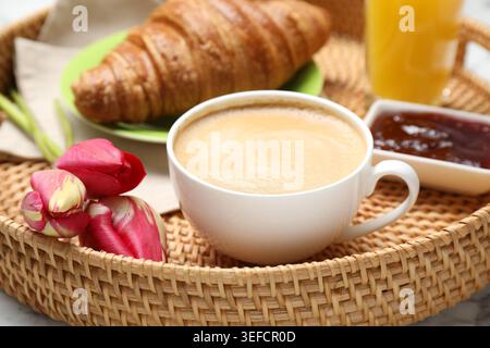 Tablett mit leckerem Frühstück und Tulpenblumen auf weißem Tisch, Nahaufnahme Stockfoto