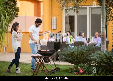 Familie aus dem Nahen Osten, die Eid iftar Abendessen und Barbecue auf einer modernen Terrasse genießen Stockfoto