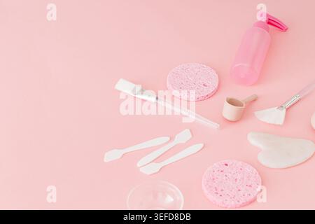 Trendige Hautpflege-Komposition mit Reinigungswerkzeugen, Kosmetikaccessoires und Essentials für Spa auf pastellrosa Hintergrund. Luxuriöse Hautpflege und Schönheit c Stockfoto