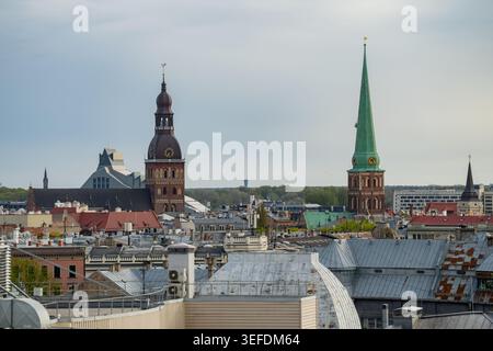 Das erhöhte Stadtbild der lettischen Hauptstadt Riga mit alten Kirchtürmen, die sich über einer dichten Stadtlandschaft aus Dächern erheben und den europäischen Bogen darstellen Stockfoto