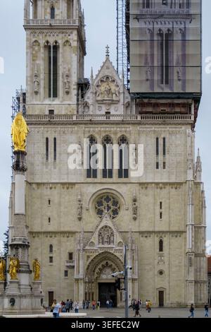 Die Fassade der historischen Zagreber Kathedrale mit Gerüsten auf dem Turm und dem Denkmal der Heiligen Maria im Vordergrund in Zagreb, Kroatien, Europa Stockfoto