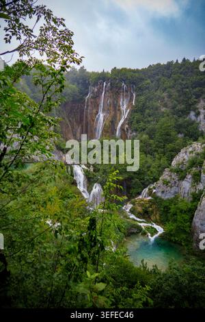 Veliki Slap Wasserfall stürzt über felsige Klippen in einen türkisfarbenen Pool, umgeben von üppigen grünen Wäldern im Nationalpark Plitvicer Seen, Kroatien Stockfoto