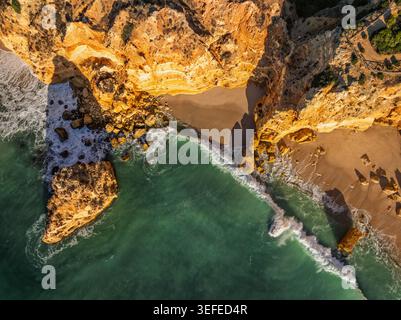 Von der Drohne aus blickt man auf den Strand Praia da Marinha in der Algarve, Portugal, mit Klippen, Meeresstapeln und Sand und Felsen. Stockfoto