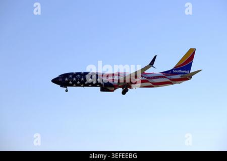 Die Boeing 737 der Southwest Airlines in ihrer speziellen „America 250“-Flaggenaufschrift, die vor einem klaren blauen Himmel absteigt. Stockfoto
