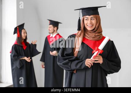 Muslimische Studentin mit Diplom im Lichtraum Stockfoto