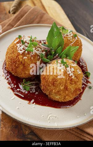 Knusprige Arancini-Vorspeise mit Parmesan und Mikrogrün, Teller, Tomatensauce, hausgemacht, keine Leute Stockfoto