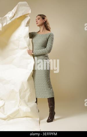 Studio Fashion Porträt der Frau trägt sage Green Crinkle Midi Kleid - moderne Damenmode Atelier Shoot - zeitgenössische Frühlingsmode Editorial Stockfoto