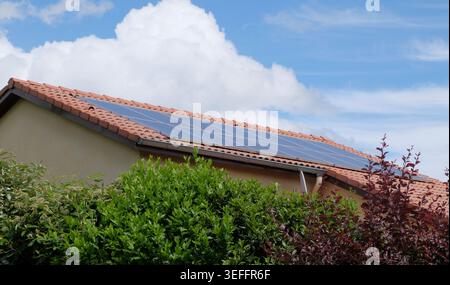 Solarpaneele auf dem Dach eines Wohnhauses unter blauem Himmel installiert. Stockfoto