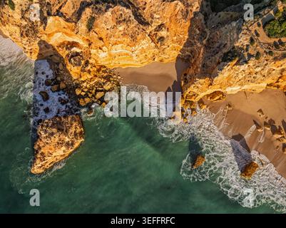 Von oben nach unten auf den Strand Praia da Marinha in der Algarve, Portugal, mit Meeresklippen, Meeresstapeln und vertikaler Küstengeometrie. Stockfoto