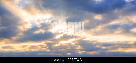 Bewölkter Himmel mit Sonnenstrahlen, die durchbrechen. Atmosphärischer natürlicher Hintergrund, geeignet für Wetter, Spiritualität und dramatische visuelle Konzepte. Stockfoto