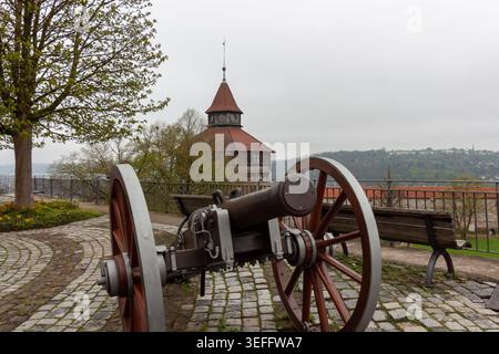Eine alte Eisenkanone auf Holzrädern am Aussichtspunkt der Esslinger Burg, mit dem Dicker Turm im Hintergrund, Esslingen am Neckar Stockfoto