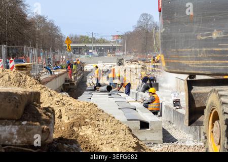 Warschau, Polen - 13. April 2026: Ein professionelles Bauteam arbeitet an einem großen Straßenausbauprojekt, bei dem Grundmaterialien und Baustoffe verlegt werden Stockfoto