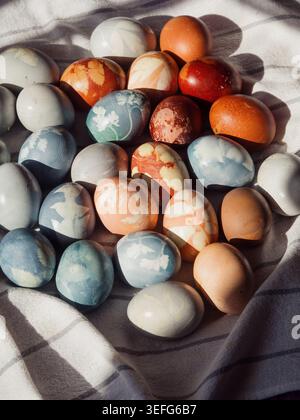 Gefärbte Ostereier mit floralen Prägungen auf weißem Leinen Stockfoto