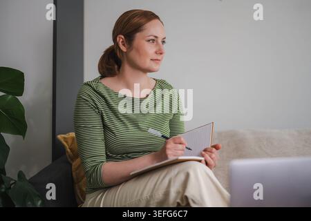 Online-Meetings und Notizen – Konzept mit einer Frau, die Remote arbeitet Stockfoto