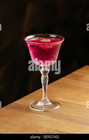 Eleganter rosafarbener Craft-Cocktail auf einer hölzernen Bar Stockfoto