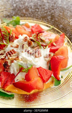 Gourmet-Tomatensalat mit Weichkäse und Pekannüssen Stockfoto
