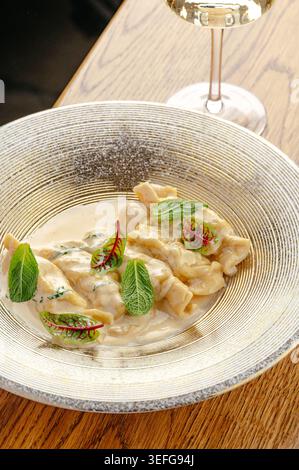 Gourmet-Ravioli in Sahnesauce mit frischen Kräutern Stockfoto