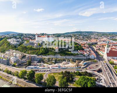 Blick aus der Vogelperspektive auf das Schloss Bratislava auf einem Hügel mit Blick auf die Stadt mit der St. Martin Kathedrale und städtischer Architektur unter einem klaren blauen Himmel in Bratislav Stockfoto