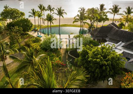 Blick aus der Vogelperspektive auf ein luxuriöses tropisches Resort mit Swimmingpool und Palmen entlang der Küste in Mauritius, Moka District, Mauritius. Stockfoto
