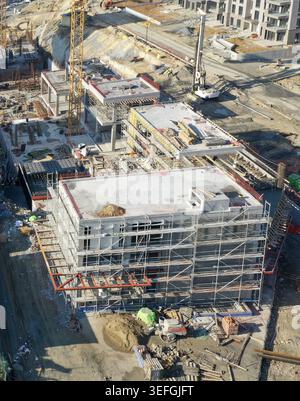 Luftaufnahme einer großen Baustelle mit Gebäuden in Entwicklung mit Gerüsten, gelben Kränen und schweren Maschinen in Avcilar, Istanb Stockfoto