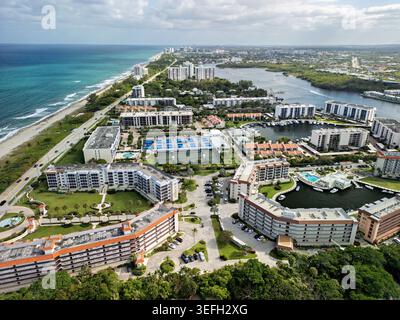 Blick aus der Vogelperspektive auf die Küstensiedlungen mit Tennisplätzen, Schwimmbädern und einem Yachthafen in der Nähe des Sandstrandes und des blauen Ozeans in Boca Raton, Flori Stockfoto