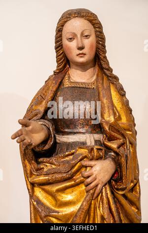 Nahaufnahme einer mittelalterlichen Holzstatue einer hübschen blonden Frau, die Gesten gibt Stockfoto