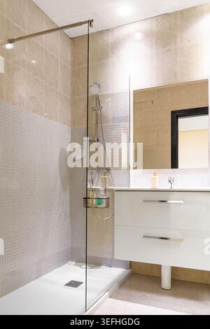 Sauberes Interieur eines modernen Hotelbades mit bodenebener Dusche und eleganter Glaswand Stockfoto
