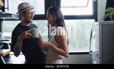 Paare genießen morgens Kaffee und Unterhaltung in ihrer Küche Stockfoto