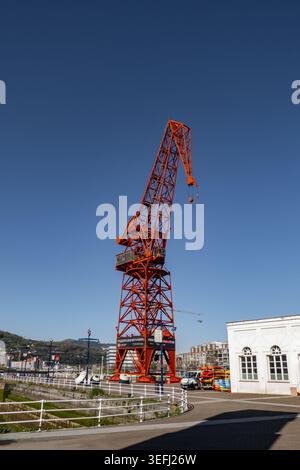 Blick auf den historischen roten Carola Crane am Anleger des maritimen Museums unter einem klaren blauen Himmel im Großraum Bilbao, Baskenland, Spanien. Stockfoto
