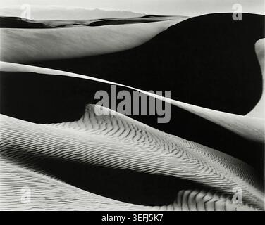 Edward Weston (1886–1958) – Dunes, Oceano – 1936 – das Bild ist ein Gelatinedruck mit skulpturalen Sanddünen in Oceano, Kalifornien, wobei der hohe Kontrast zwischen hellen und dunklen Bereichen hervorgehoben wird, um abstrakte Formen zu schaffen. Stockfoto
