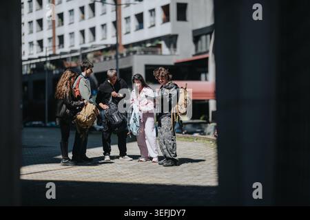 Gruppe von Schulfreunden mit Rucksäcken, die sich unterhalten und Notizen in einem Innenhof des städtischen Campus überprüfen Stockfoto