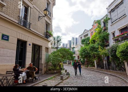Paris, Frankreich. 20. August 2019: Fußgänger und historische Häuser entlang der Rue de l'Abreuvoir im Pariser Viertel Montmartre. Stockfoto