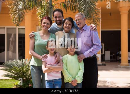 Moderne arabische Mehrgenerationsfamilie aus dem Nahen Osten, die zu Hause gemeinsam im Freien lächelt Stockfoto