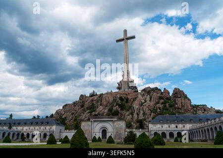 San Lorenzo de El Escorial, Spanien - 15. Mai 2026: Weitwinkelblick auf das monumentale Granitkreuz und die umliegenden Gebäude im Tal der Stockfoto