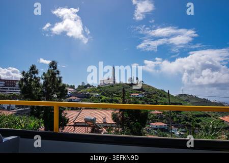 Funchal Madeira, 9. Mai 2026 Panoramablick auf eine hügelige, bewachsene Landschaft unter einem hellblauen Himmel mit verstreuten weißen Wolken Stockfoto