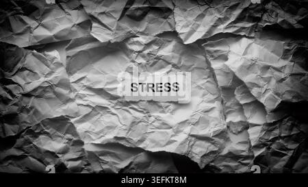 Ein zerrissenes Stück Papier mit dem Wort Stress auf einem Hintergrund aus chaotischen zerknitterten Papierstrukturen. Schwarz-weiß. Nahaufnahme. Stockfoto
